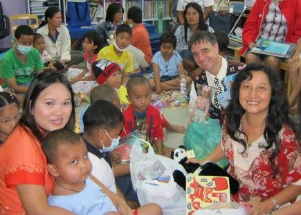 TFI members Victor and Rose with happy children in Thailand.