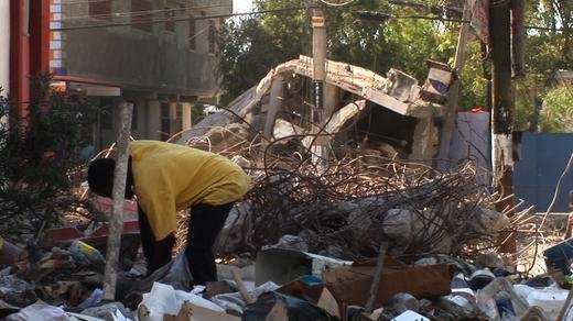 A woman digs through what was left of her home