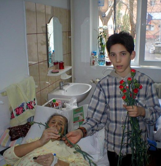 Bogdan [12] giving flowers to an elderly lady at the Sf Luca hospice, Bucharest