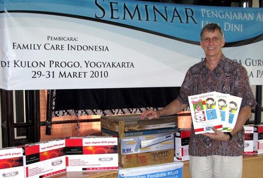 Daniel with the activity books and video players donated to the schools at the Jogja early learning seminars.