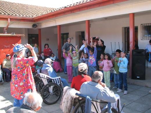 Family volunteers teaching the children a motion song at a shelter