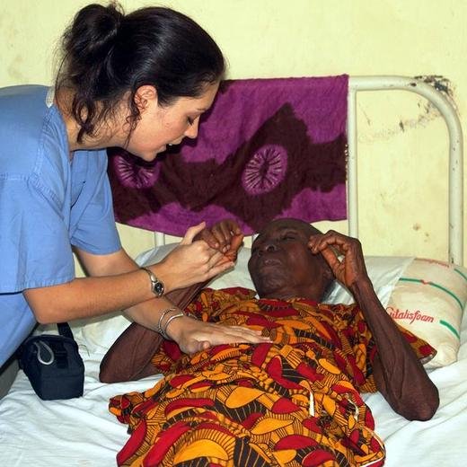 Volunteer Rima praying with a patient