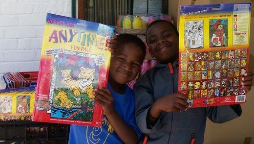 Helping Hand, à Cape Town : des enfants montrent les jouets qui leur ont été donnés