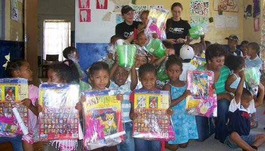 Lisa and Michelle pose with underprivileged children and donated gifts