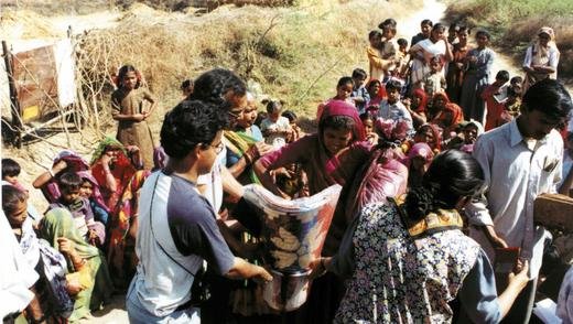 Family volunteers distributing earthquake relief supplies in Naliya, India.