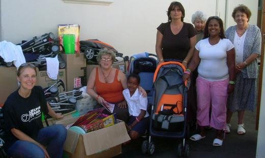 Suzanne (L) posing with the donated prams and toys for women and children