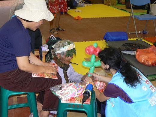 Vicky and Hannah, Family International volunteers, encourage a victim of typhoon Morakot