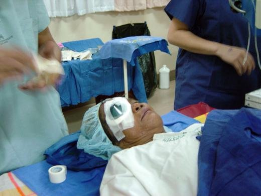 Volunteer ophthalmologists performing eye surgery on a prison inmate, Philippines