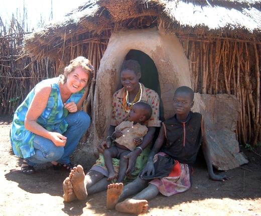 Robin with a mother and her children outside their hut in Uganda