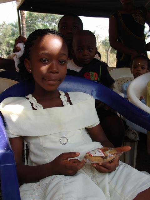 One of the orphan children with her gift bag of donated snacks