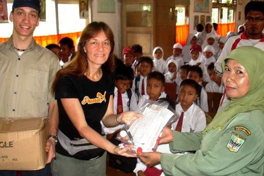 Mary and Joe, volunteers with the Family International, presenting school materials at the Padang earthquake site.