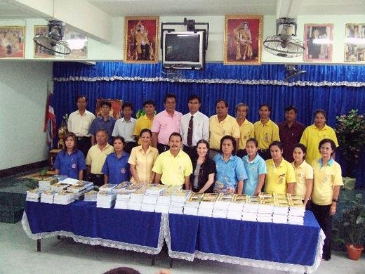 Family members and school faculty with donated educational materials