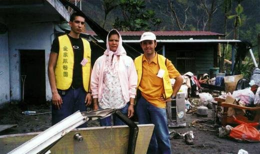 Mark (left) and Pietro with a survivor in front of what is left of her home.